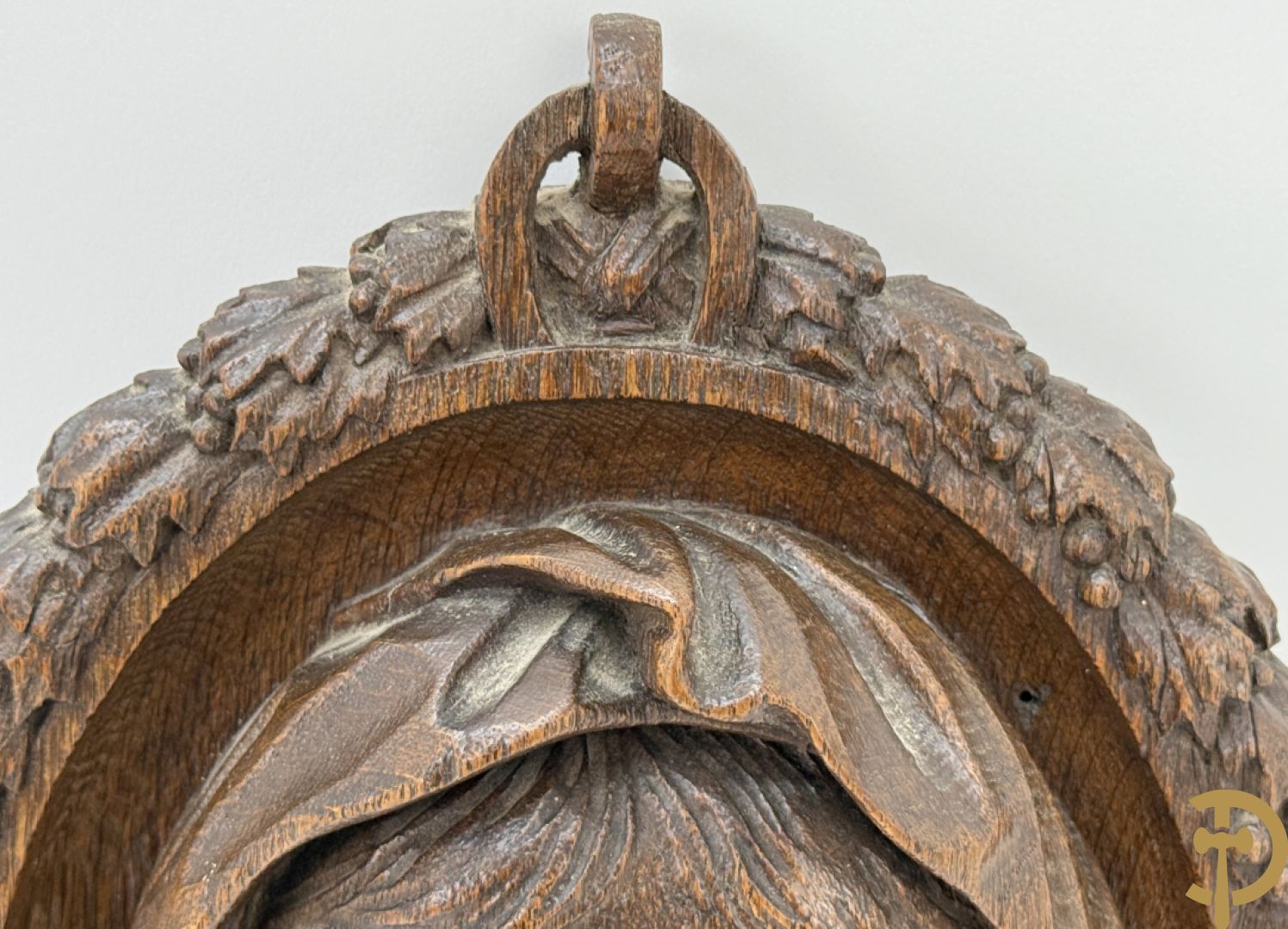 Houtgesculpteerd basrelief van wenende dame in cartouche met accanthusranken