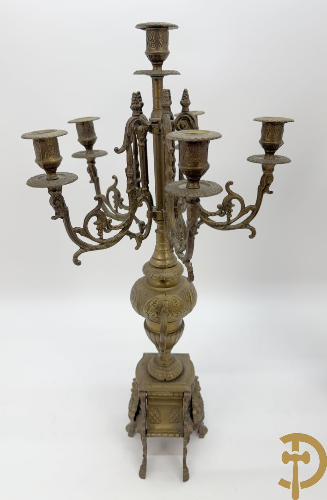 Driedelige koperen garnituur, klok geflankeerd door paar vijfarmige kandelaars