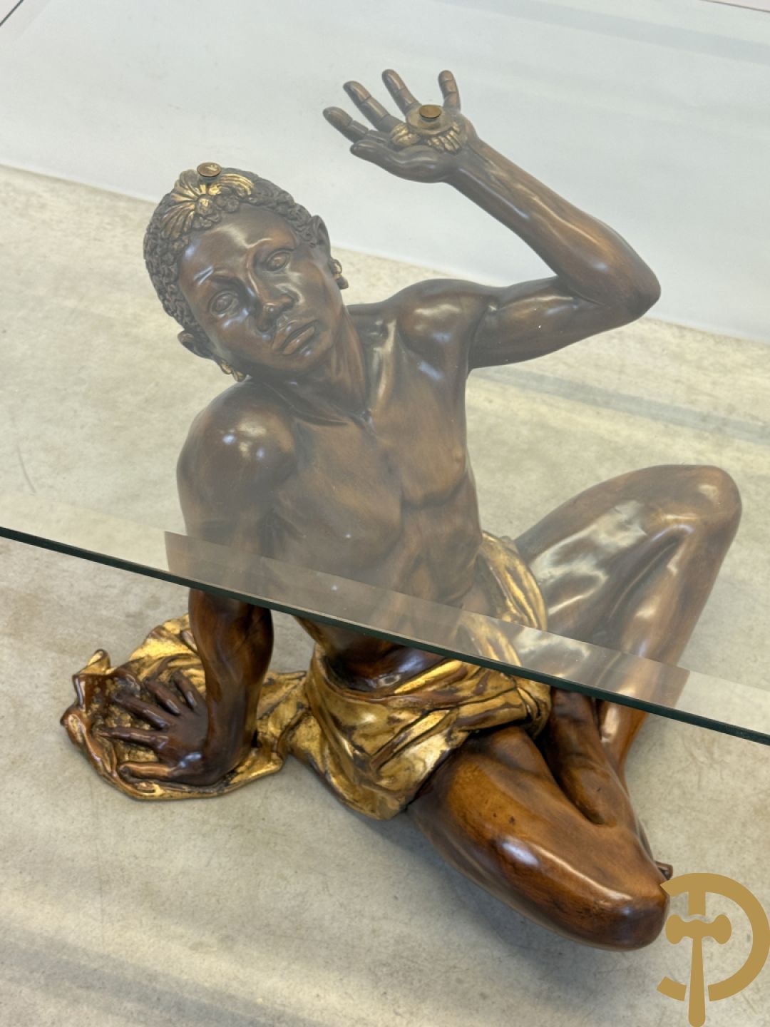 Salontafel met een paar moren met vergulde lendendoek dragende een achthoekig geslepen glazen blad