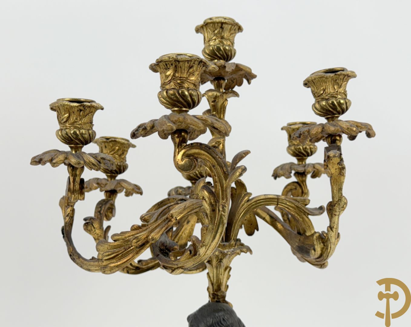 Bronzen cupido dragende een zevenarmige kandelaar