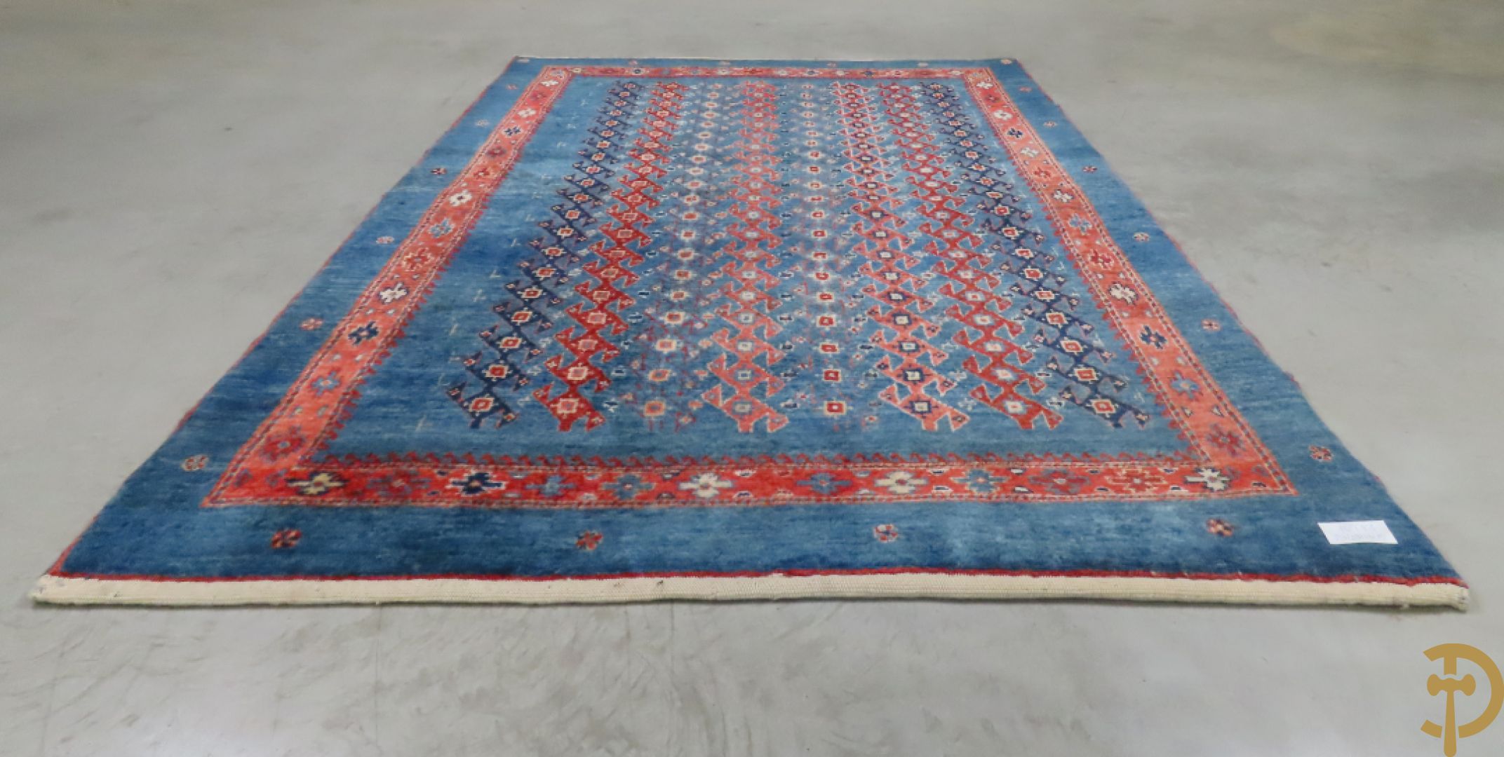 Oosters handgeknoopt tapijt met geometrische patronen op blauwe fond