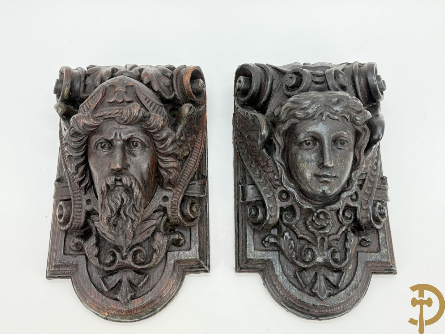 Paar muurhoeksteunen van hout met gesculpteerde hoofden man en vrouw