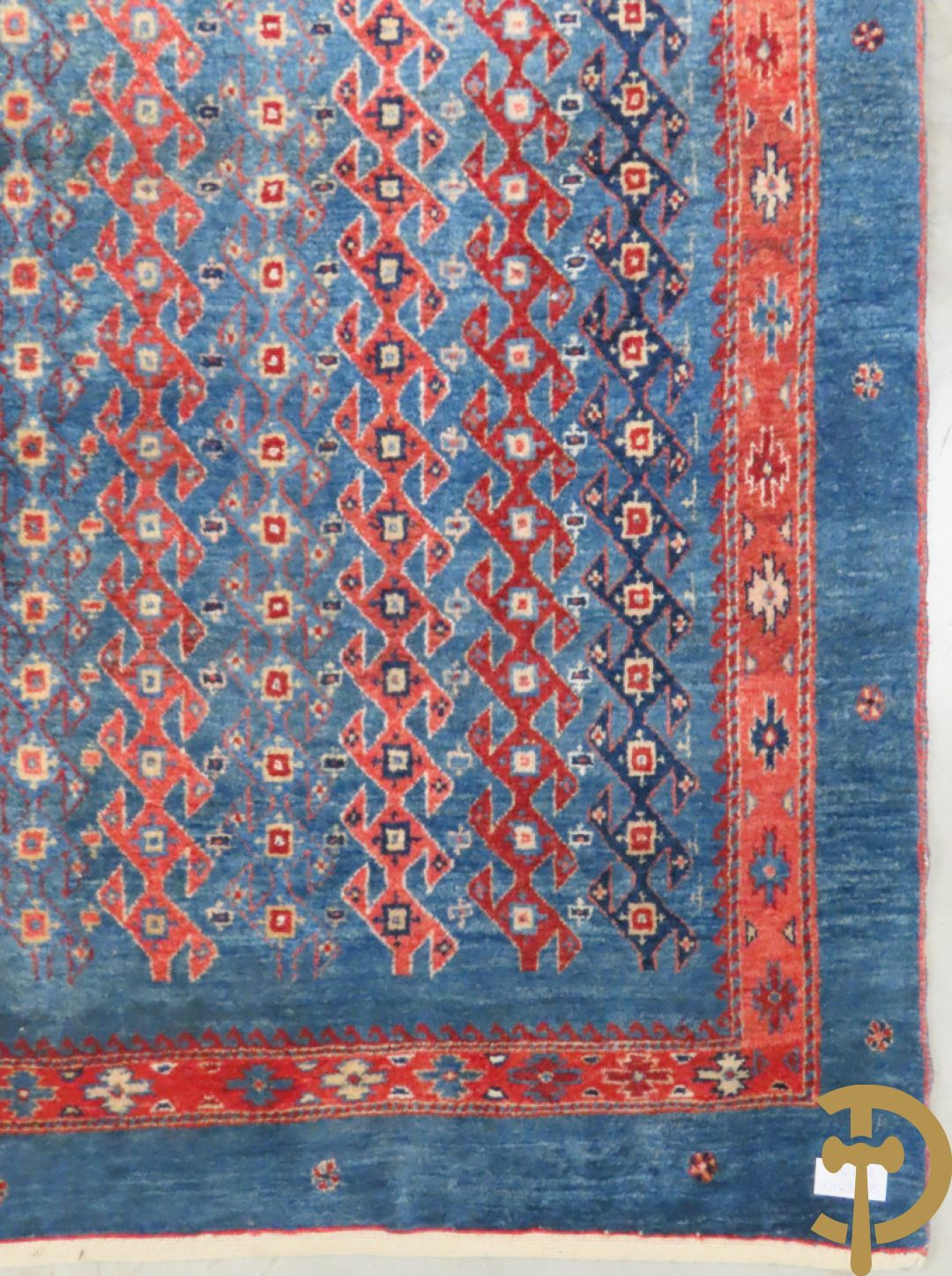 Oosters handgeknoopt tapijt met geometrische patronen op blauwe fond