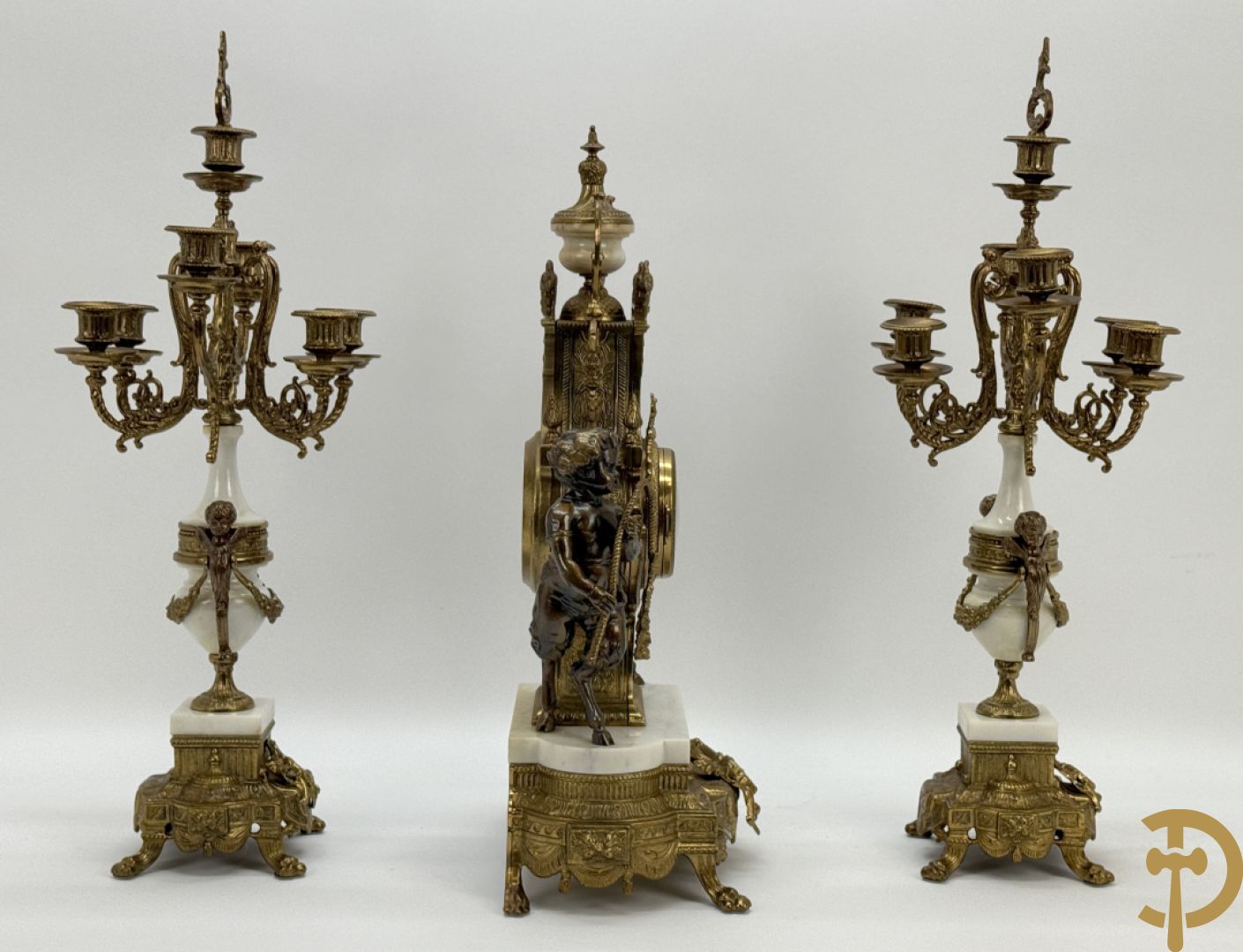 Driedelige koperen garnituur, centraal met harp geflankeerd door paar cupido