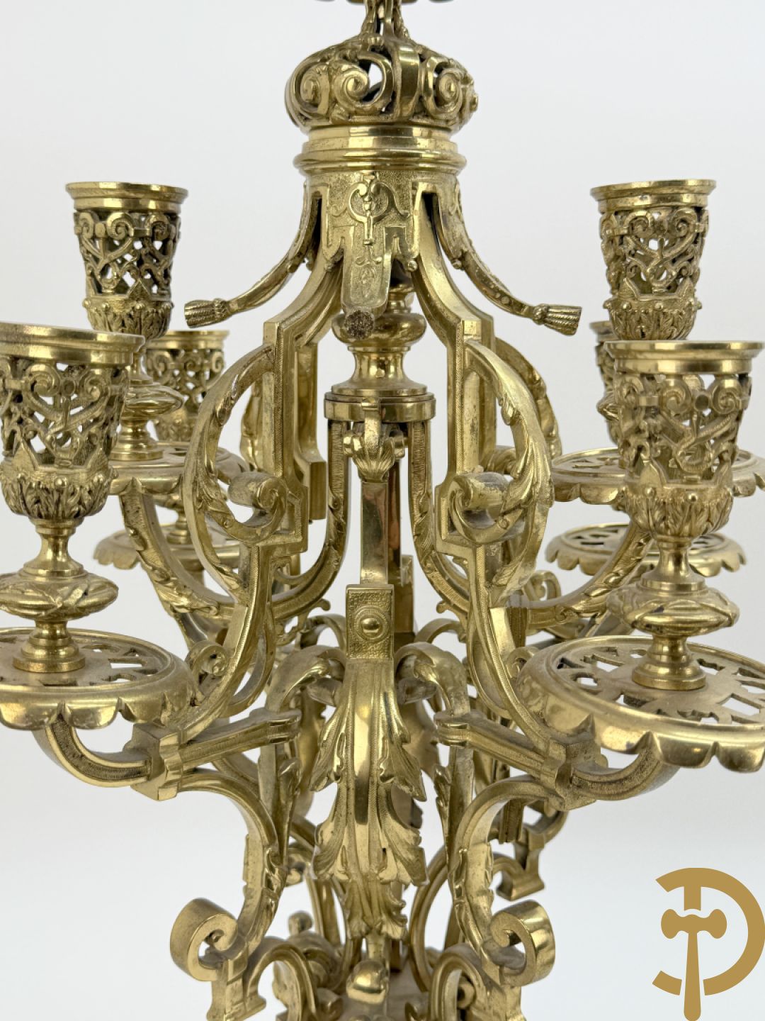 Driedelige bronzen vergulde garntiuur bestaande uit klok met medusahoofden en sfinxen, geflankeerd door paar zevenarmige kandelaars met accanthusranken en sfinxen