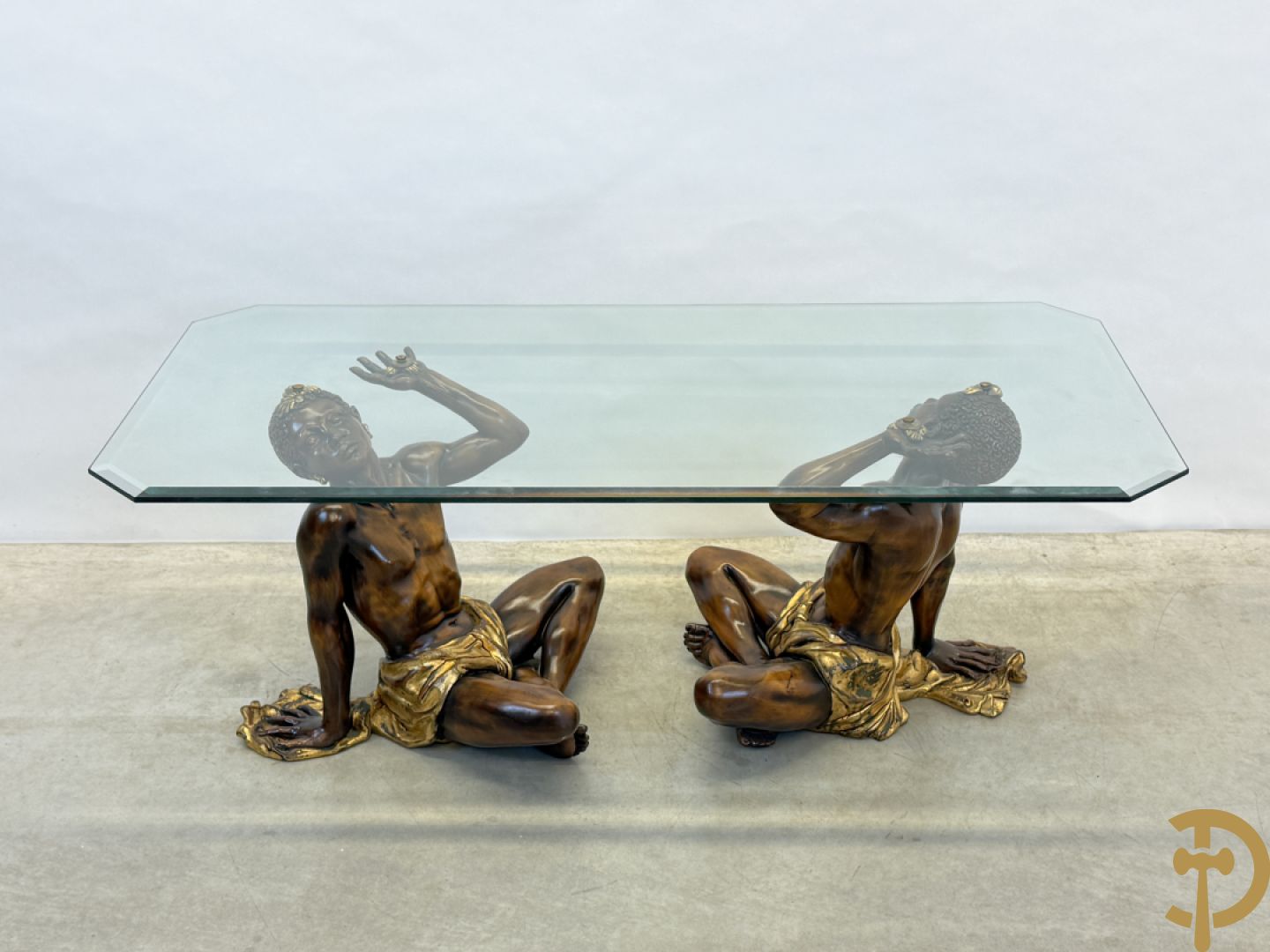 Salontafel met een paar moren met vergulde lendendoek dragende een achthoekig geslepen glazen blad