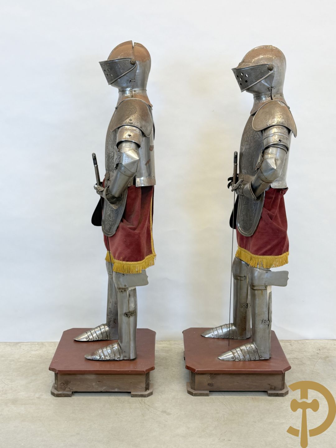 Paar ijzeren decoratieve harnassen ridderuitrusting met geciseleerde motieven op de elementen, met zwaard en ridderhelm - op statief - vermoedelijk Spaans 1930-1940