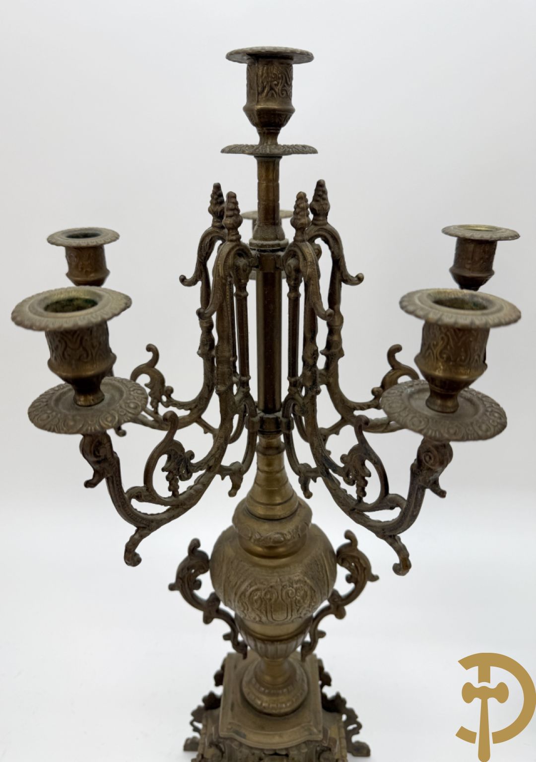 Driedelige koperen garnituur, klok geflankeerd door paar vijfarmige kandelaars