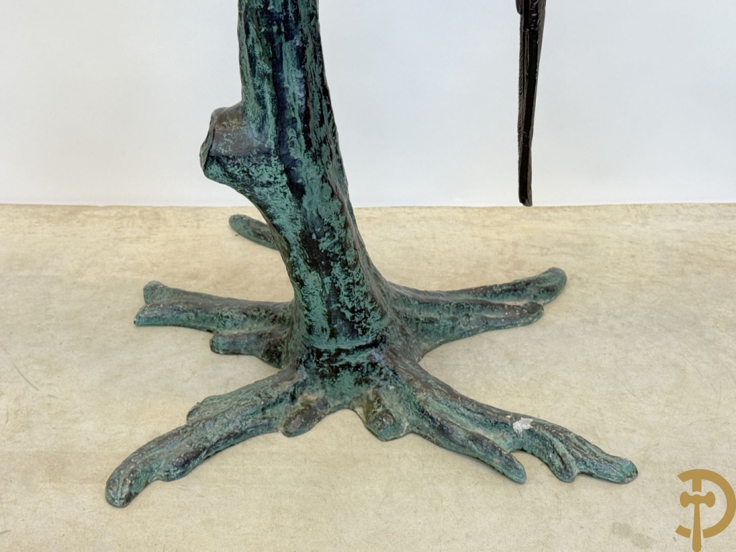 Metalen gepatineerde papegaai op boomstronk