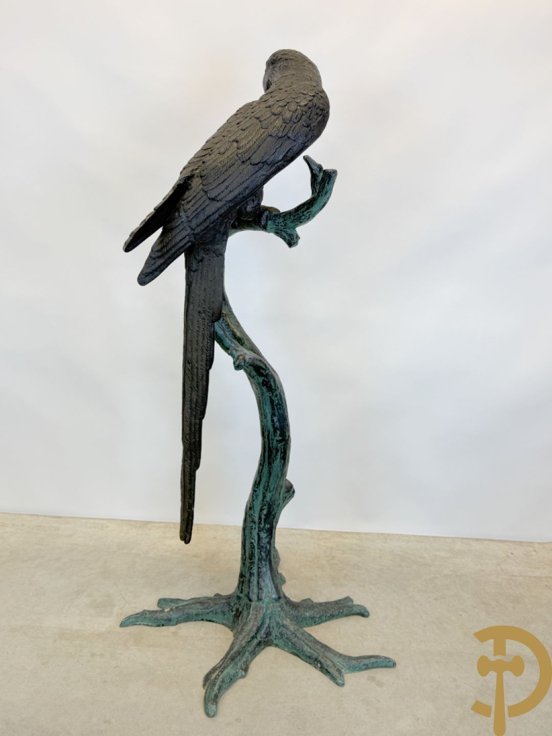 Metalen gepatineerde papegaai op boomstronk