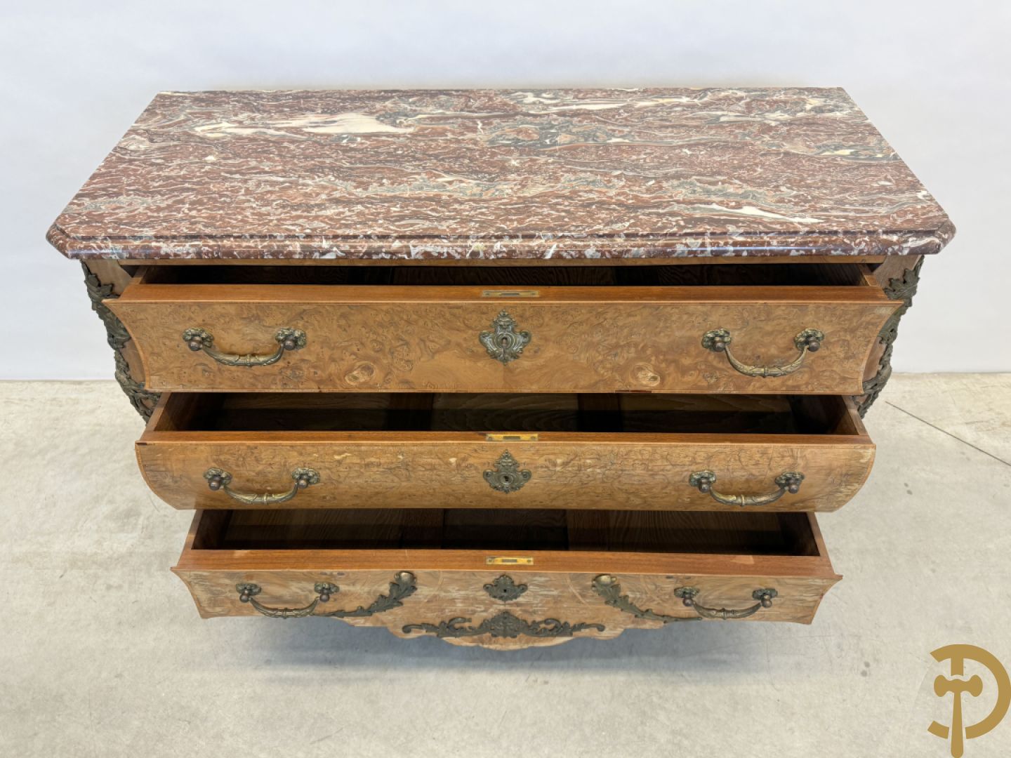 Wortelnotehouten drieladencommode met bronsbeslag van mazarinkoppen en accanthusranken, bovenaan met rood geaderd marmeren blad