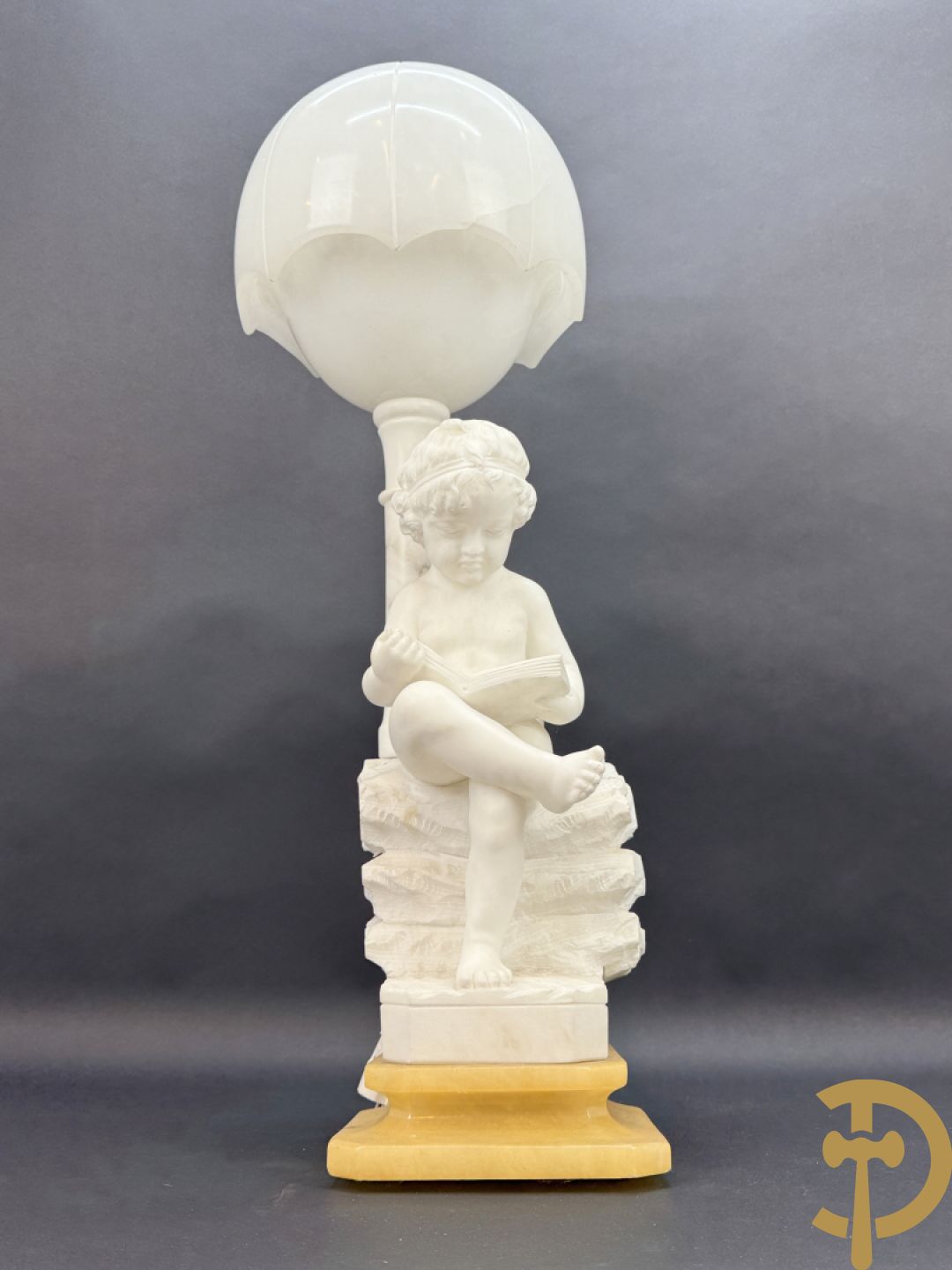 Albast beeld van jongen met boek en lamp