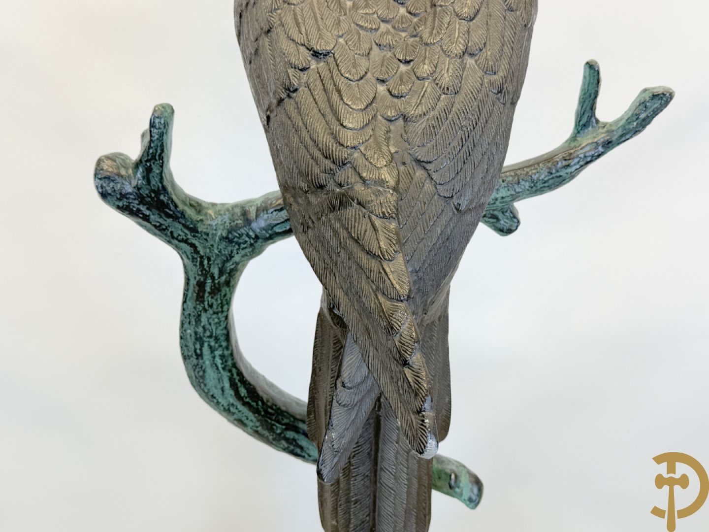 Metalen gepatineerde papegaai op boomstronk