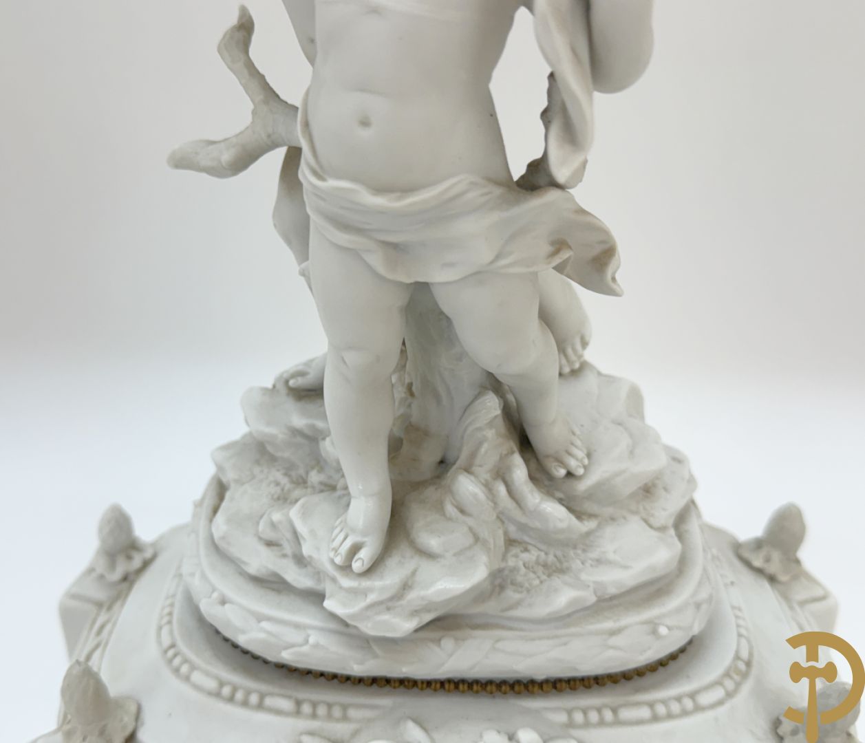 Driedelige porseleinen garnituur bestaande uit pendule bezet met lieftallig koppel, geflankeerd door paar kandelaars met cupido