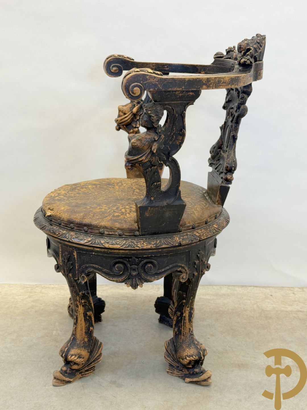 Gesculpteerde draaibare gondelvormige stoel steunend op 4 poten in de vorm van dolfijnen, bovenaan met kariathiden en engelenkoppen