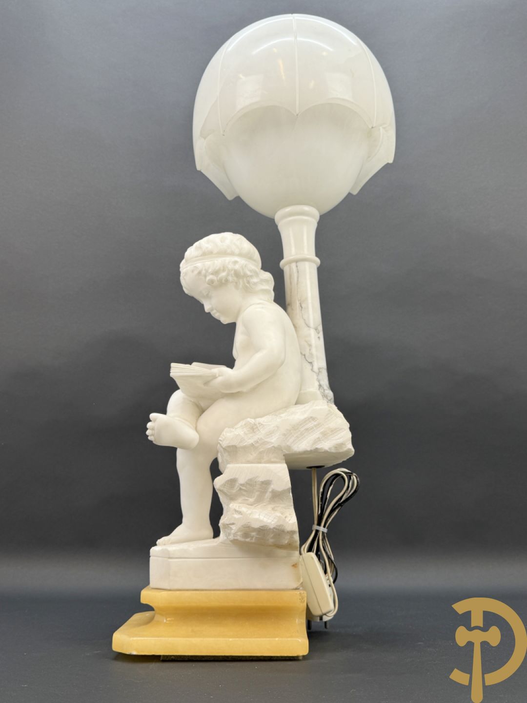 Albast beeld van jongen met boek en lamp