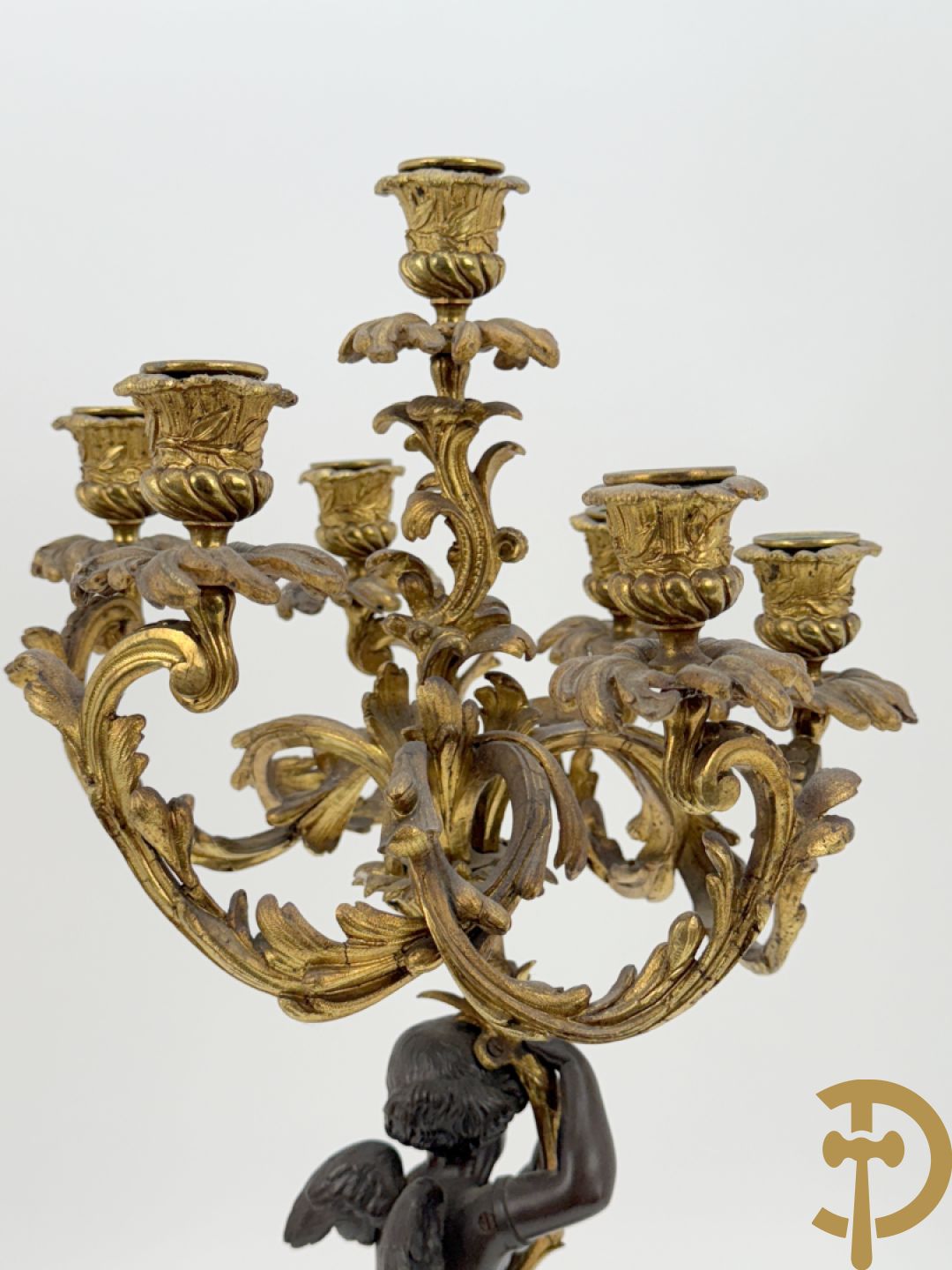 Bronzen cupido dragende een zevenarmige kandelaar