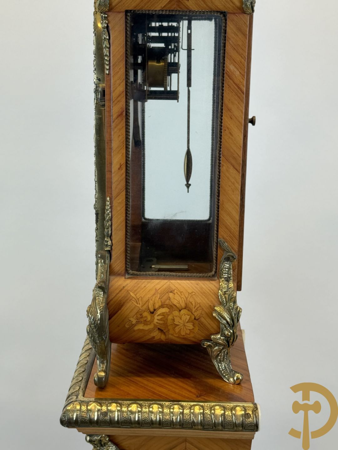 Notelaren pendule met bloemenmarquetterie en bronsbeslag, bovenaan bekroond met bronzen figuur - met bijhorende sokkel in notelaar met bronsbeslag