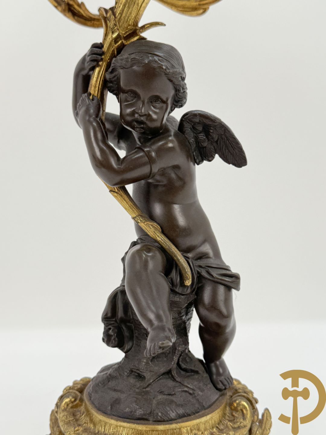 Bronzen cupido dragende een zevenarmige kandelaar