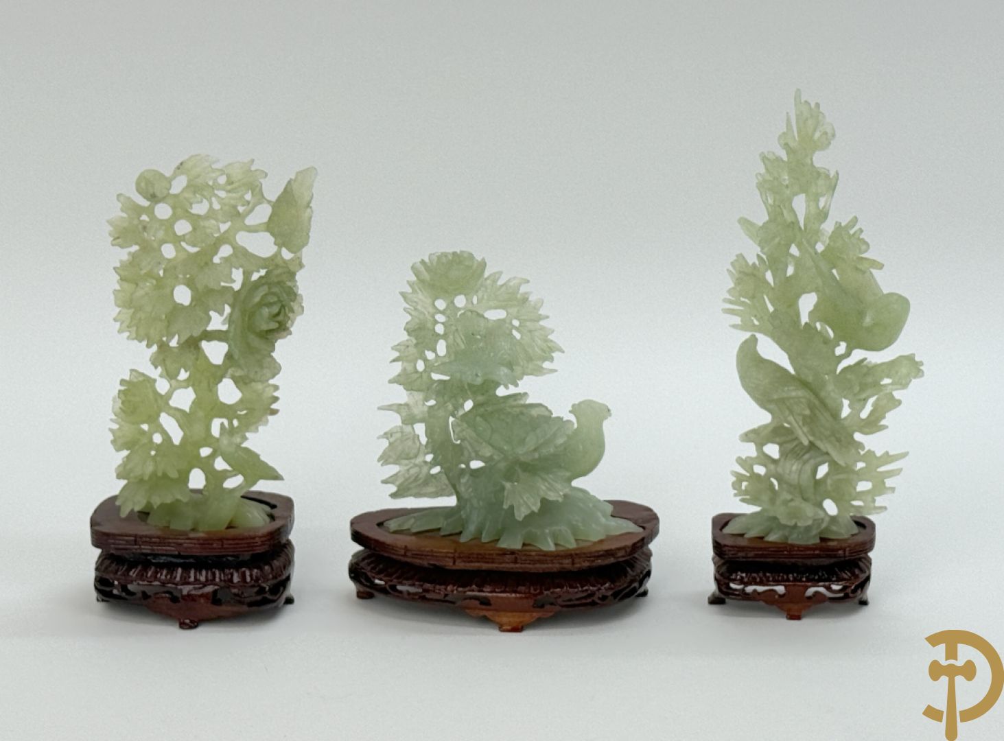 Drie jade sculpturen van vogels met bloemen op sokkel