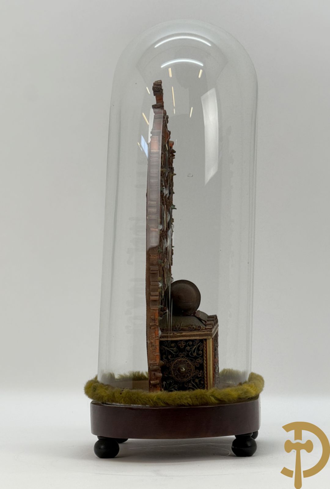 Relikwiehouder in de vorm van een altaar met Christusnagel en omgeven door papperollen - onder stolp