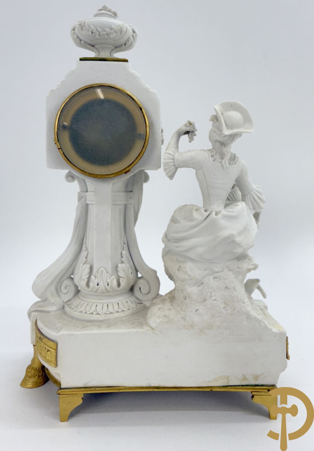 Driedelige porseleinen garnituur met bronsbeslag bestaande uit pendule met dame en amfoor geflankeerd door paar kandelaars bezet met personages