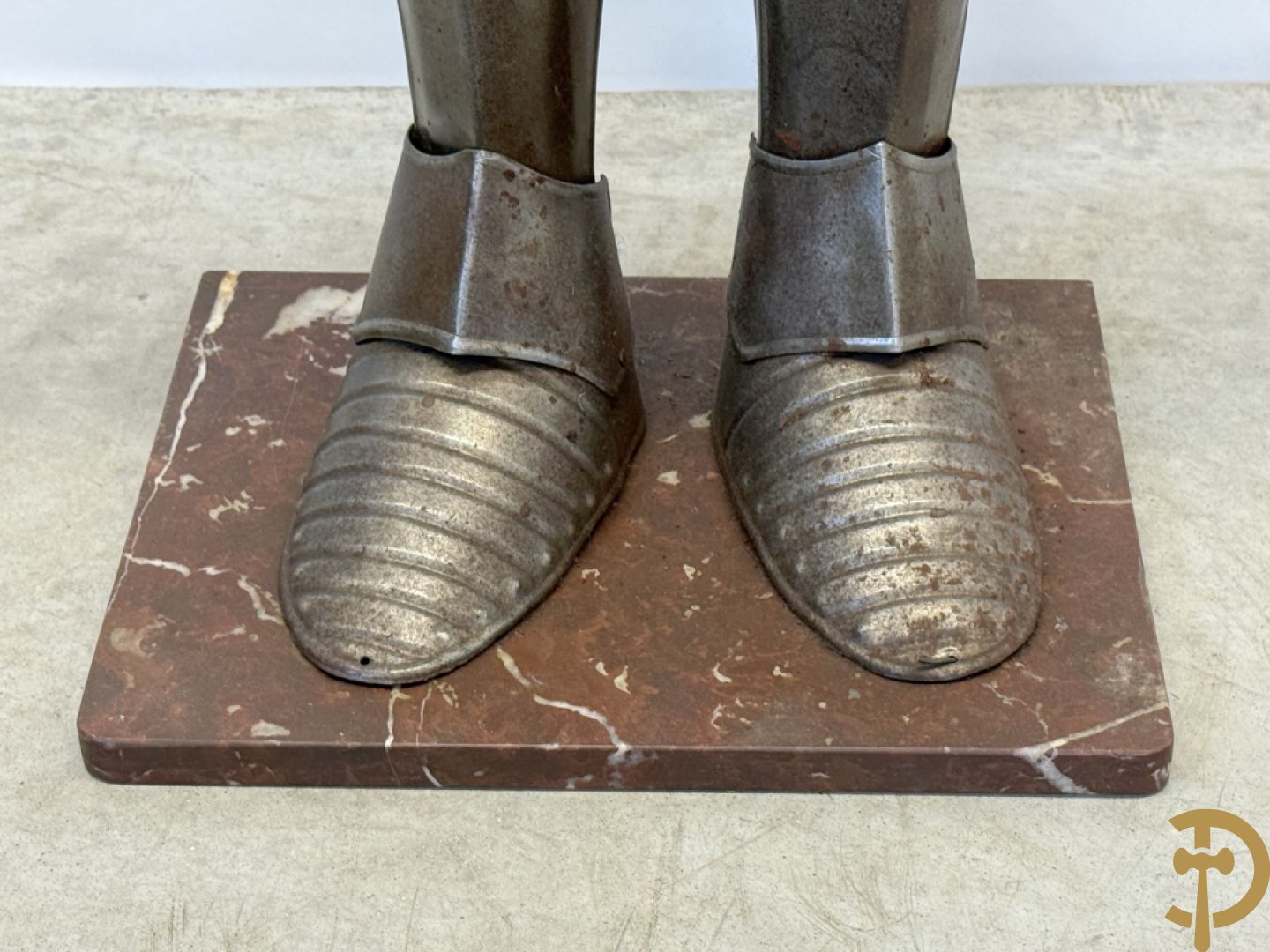 Decoratief plaatstalen ridderharnas met zwaard op marmeren voet