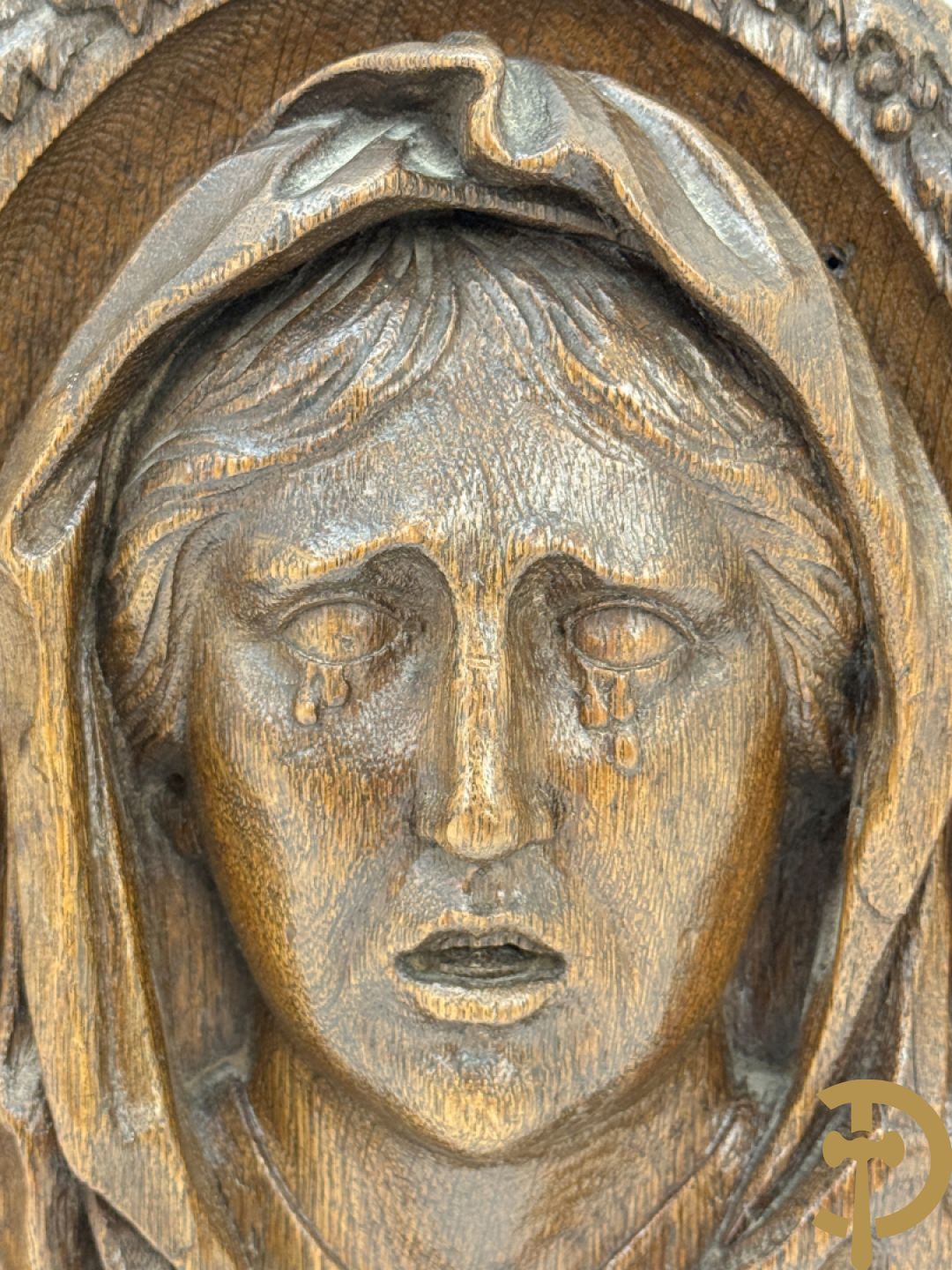 Houtgesculpteerd basrelief van wenende dame in cartouche met accanthusranken