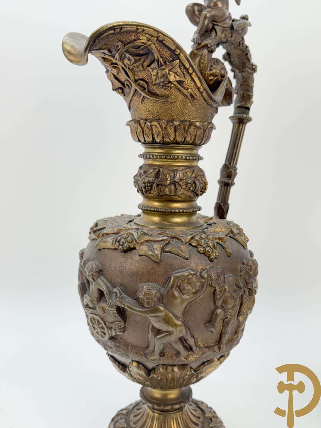 Paar bronzen schenkkannen met basrelief van putti en accanthusranken