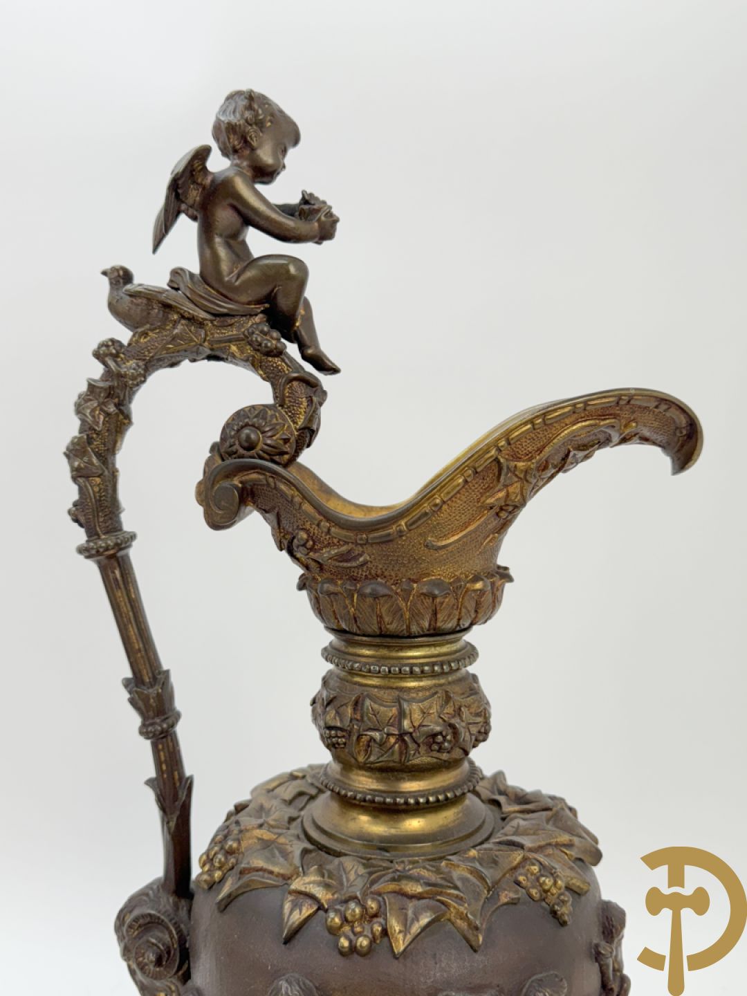 Paar bronzen schenkkannen met basrelief van putti en accanthusranken