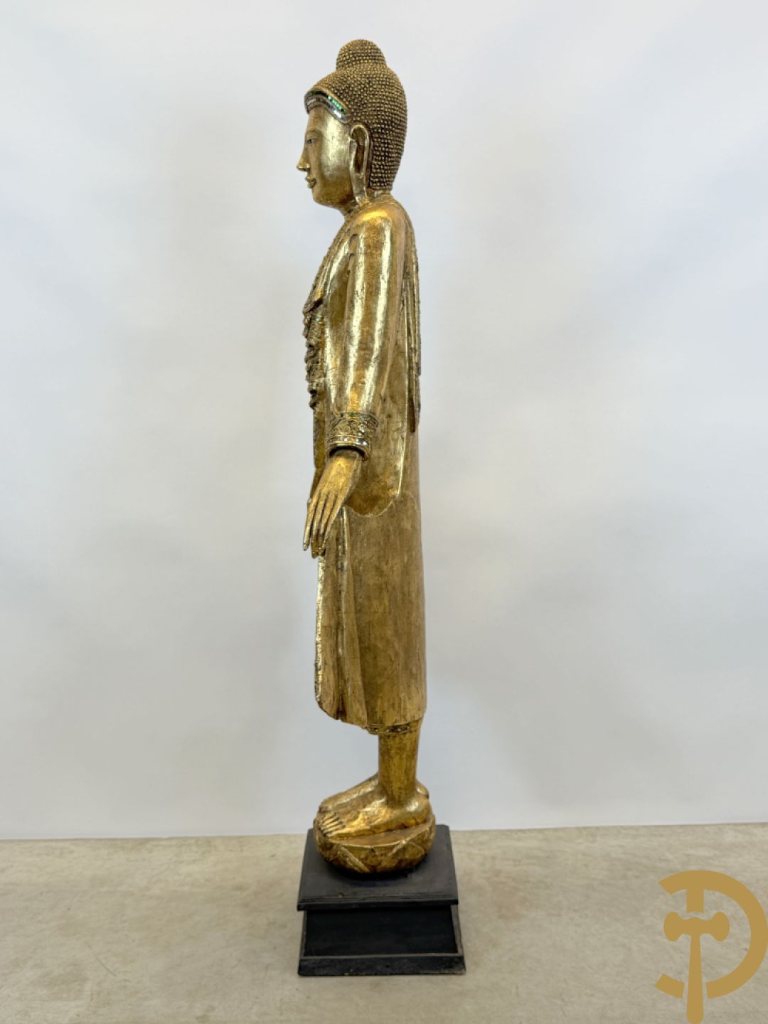 Vergulde houtgesculpteerde staande boedha bezet met spiegeltjes, op sokkel