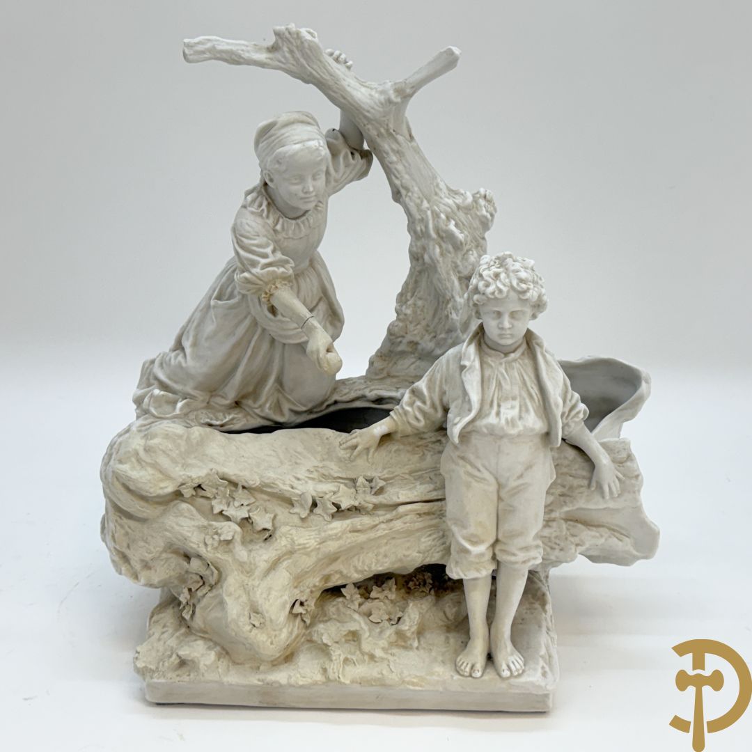 Ongetekend, witte biscuit van jongen en meisje bij boomstronk