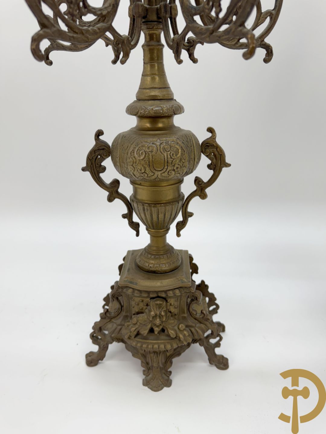 Driedelige koperen garnituur, klok geflankeerd door paar vijfarmige kandelaars