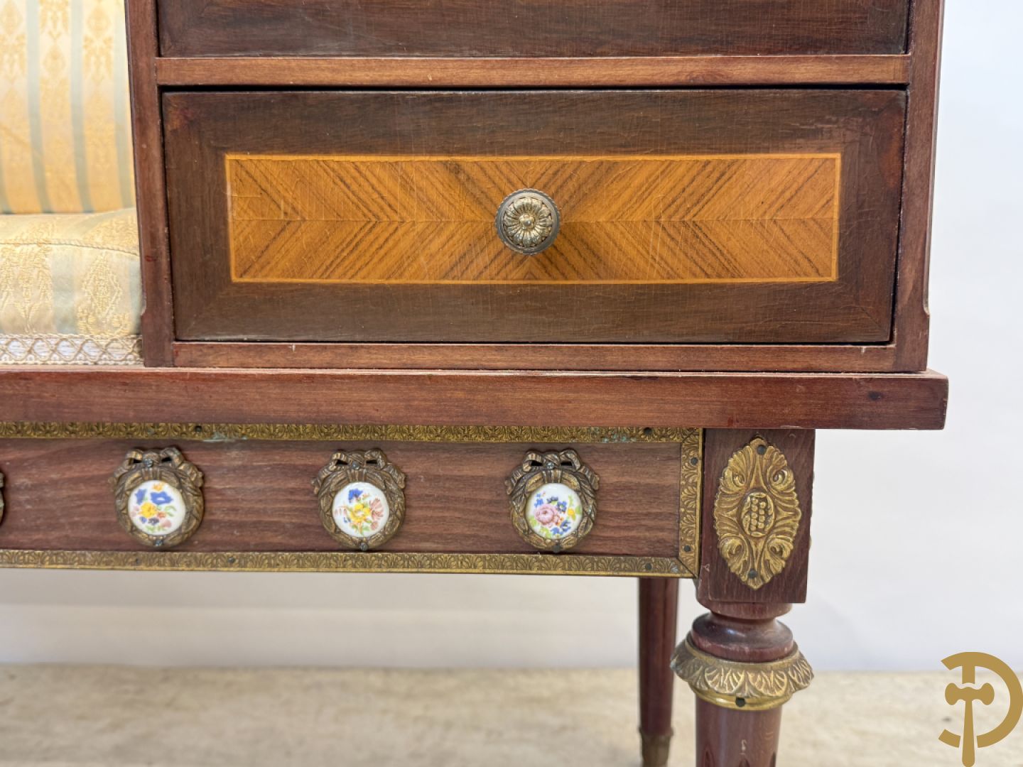 Banquette met ingebouwd bijzettafeltje bezet met porseleinen plakkettes op gecanneleerde poten