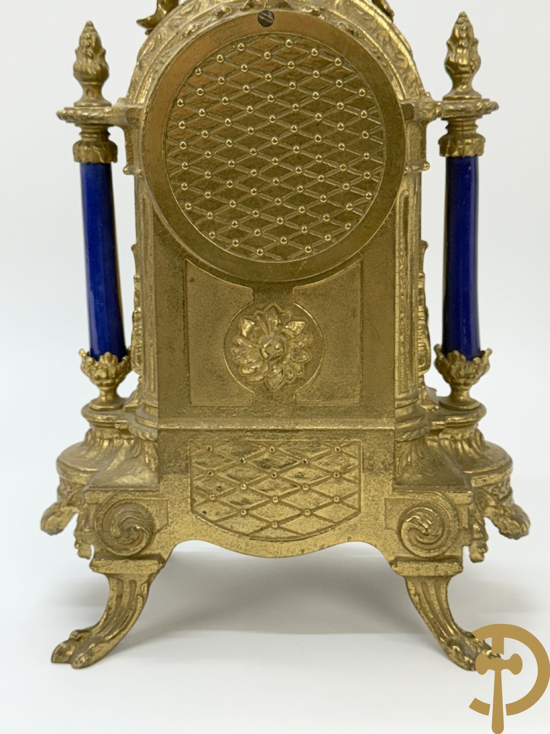 Driedelige koperen garnituur bestaande uit pendule met beschilderd romantisch tafereel en amfoor, zijdelings bezet met paar cassolettes met geanimeerde scènes, onleesbaar getekend rechts onder klok