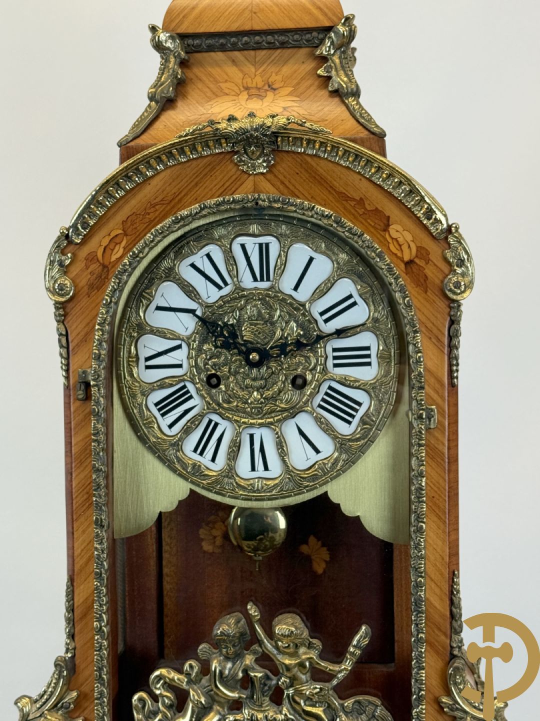 Notelaren pendule met bloemenmarquetterie en bronsbeslag, bovenaan bekroond met bronzen figuur - met bijhorende sokkel in notelaar met bronsbeslag