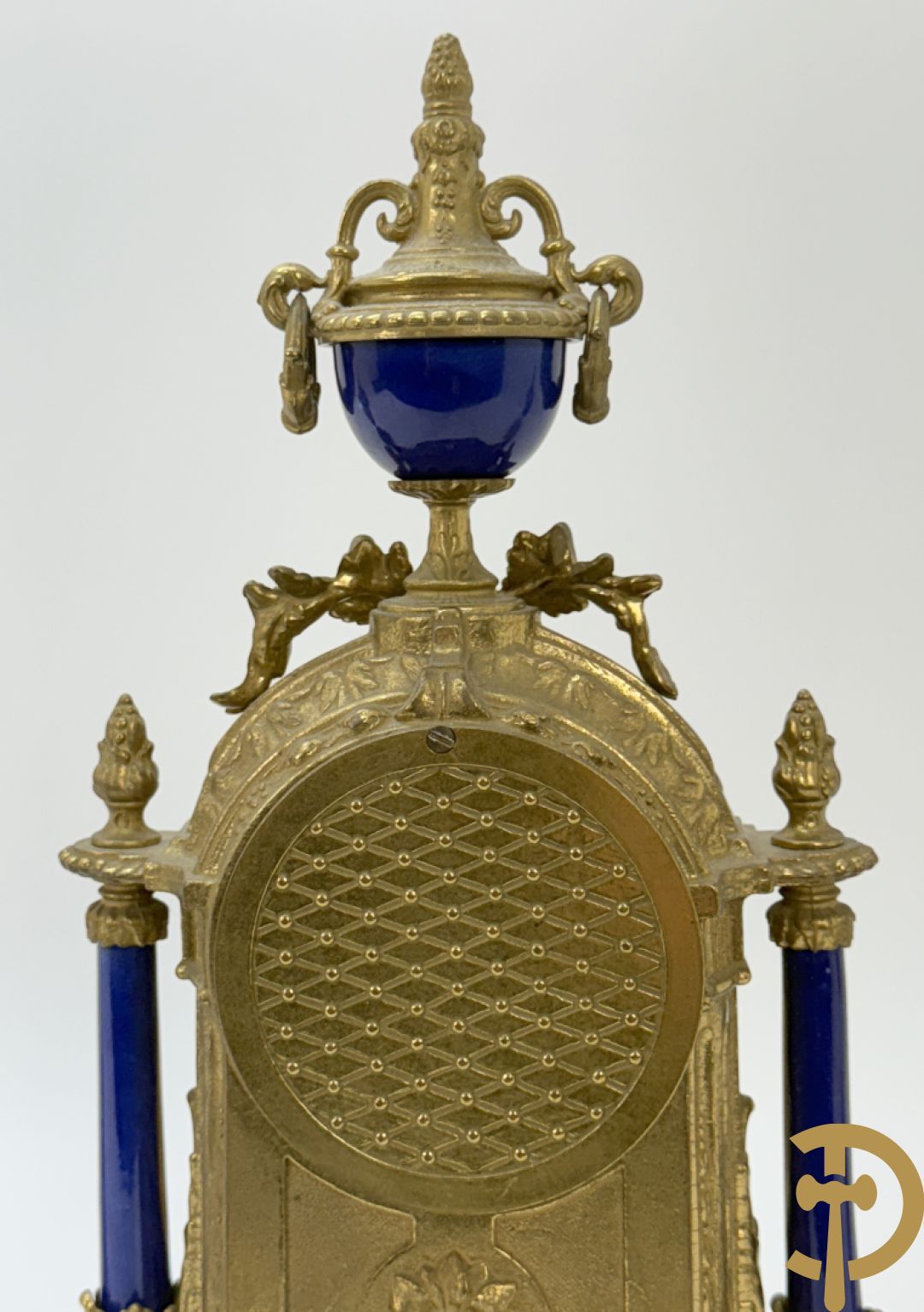 Driedelige koperen garnituur bestaande uit pendule met beschilderd romantisch tafereel en amfoor, zijdelings bezet met paar cassolettes met geanimeerde scènes, onleesbaar getekend rechts onder klok