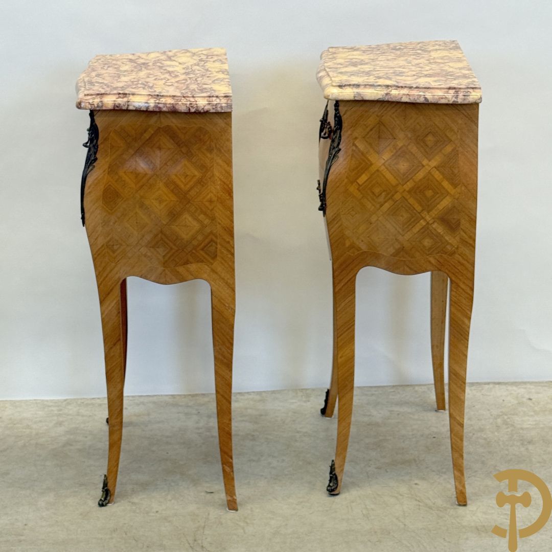 Paar notelaren bijzetkastjes met 2 lades en bezet met bronsbeslag, bovenaan met marmeren blad, op voluutvormige poten