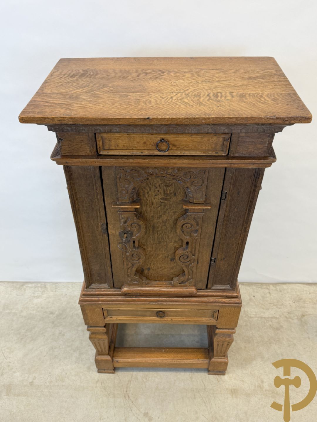 Massief eiken ééndeurskast op onderstel met lade bovenaan, lade onderaan, sculptuur in zijkant en deur