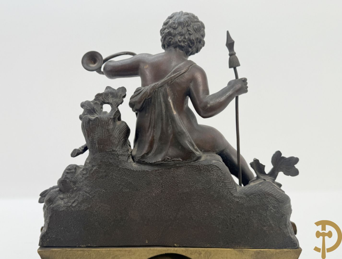 Zamak pendule met accanthusranken en bekroond met cupido met jachthoorn