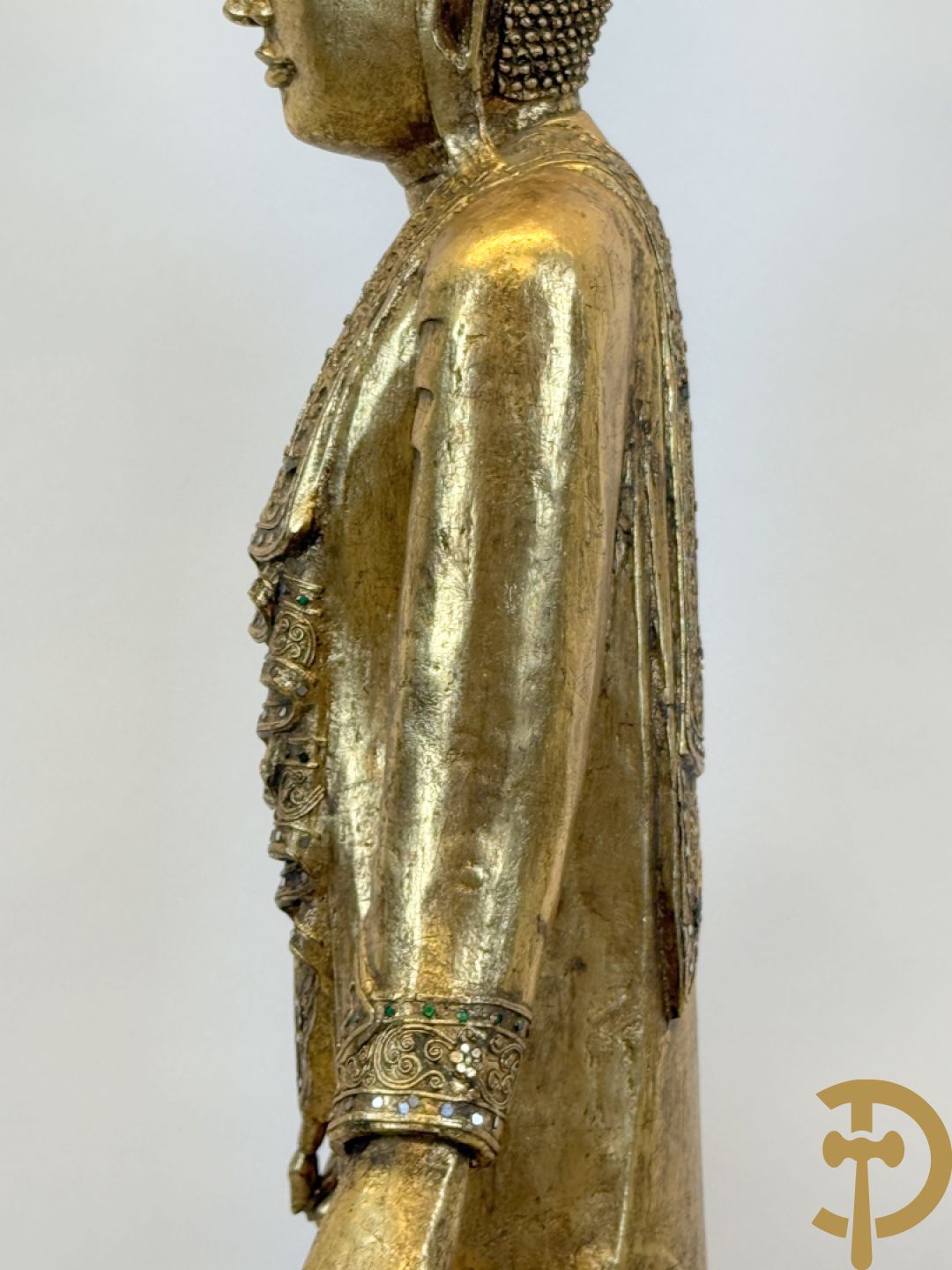 Vergulde houtgesculpteerde staande boedha bezet met spiegeltjes, op sokkel
