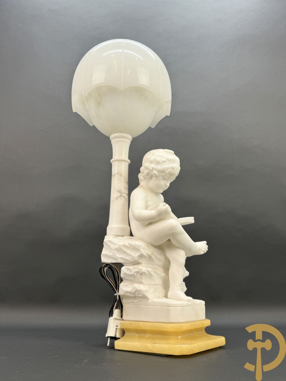 Albast beeld van jongen met boek en lamp