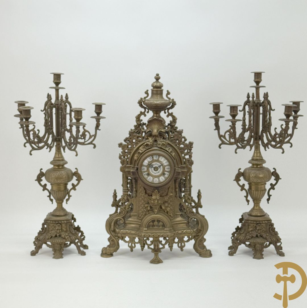 Driedelige koperen garnituur, klok geflankeerd door paar vijfarmige kandelaars