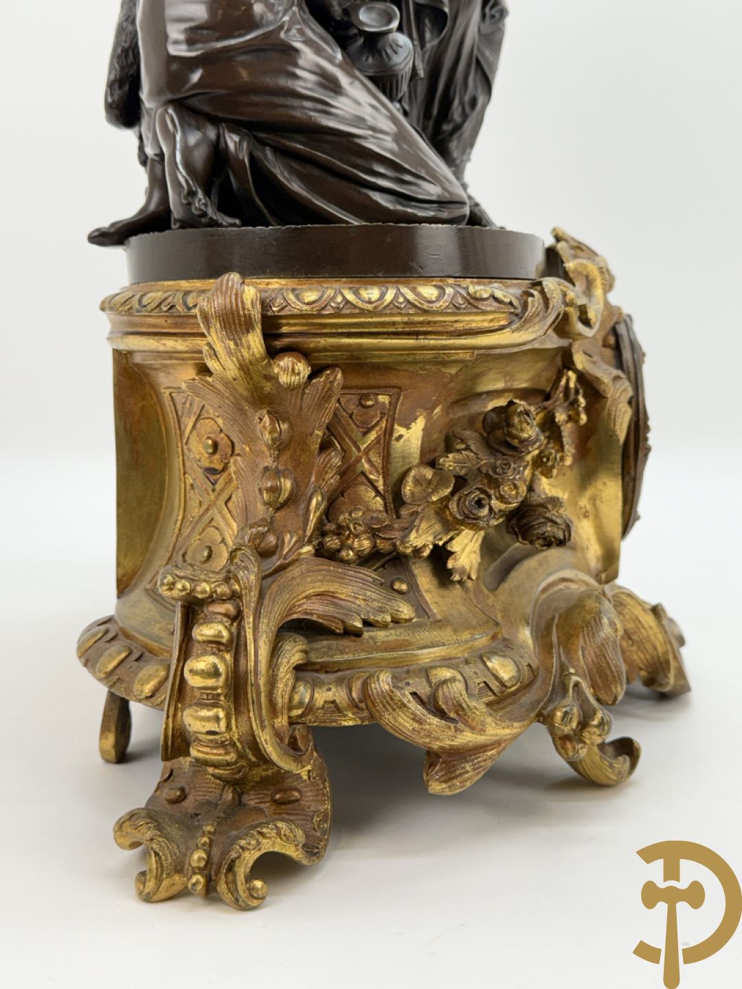 Driedelige bronzen garnituur bestaande uit middenstuk met bronzen vuurvergulde klok, Daubrée gemerkt à Nancy, bovenaan bekroond met Cleopatra met drinkbeker - getekend van Cumberworth sculpteur - geflankeerd door paar cupido