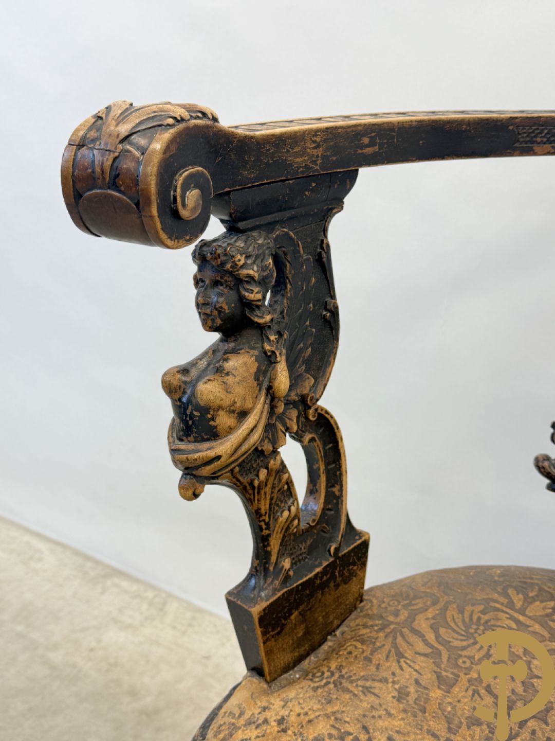 Gesculpteerde draaibare gondelvormige stoel steunend op 4 poten in de vorm van dolfijnen, bovenaan met kariathiden en engelenkoppen