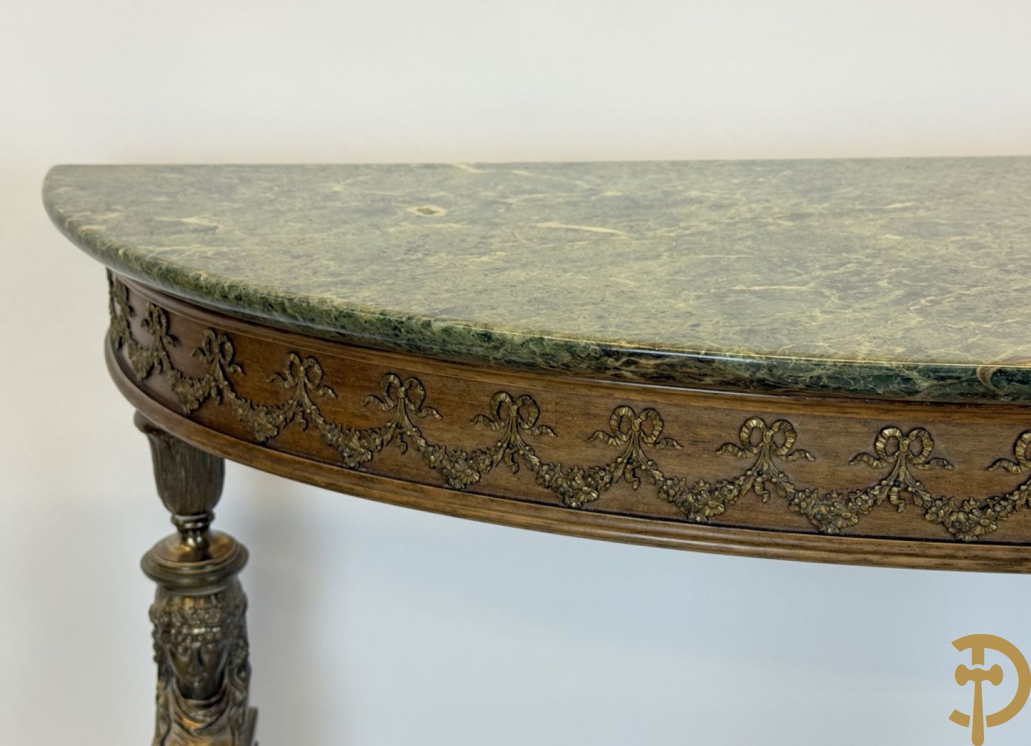 Console op bronzen poten met dameshoofden bezet, bovenaan met groen marmeren blad