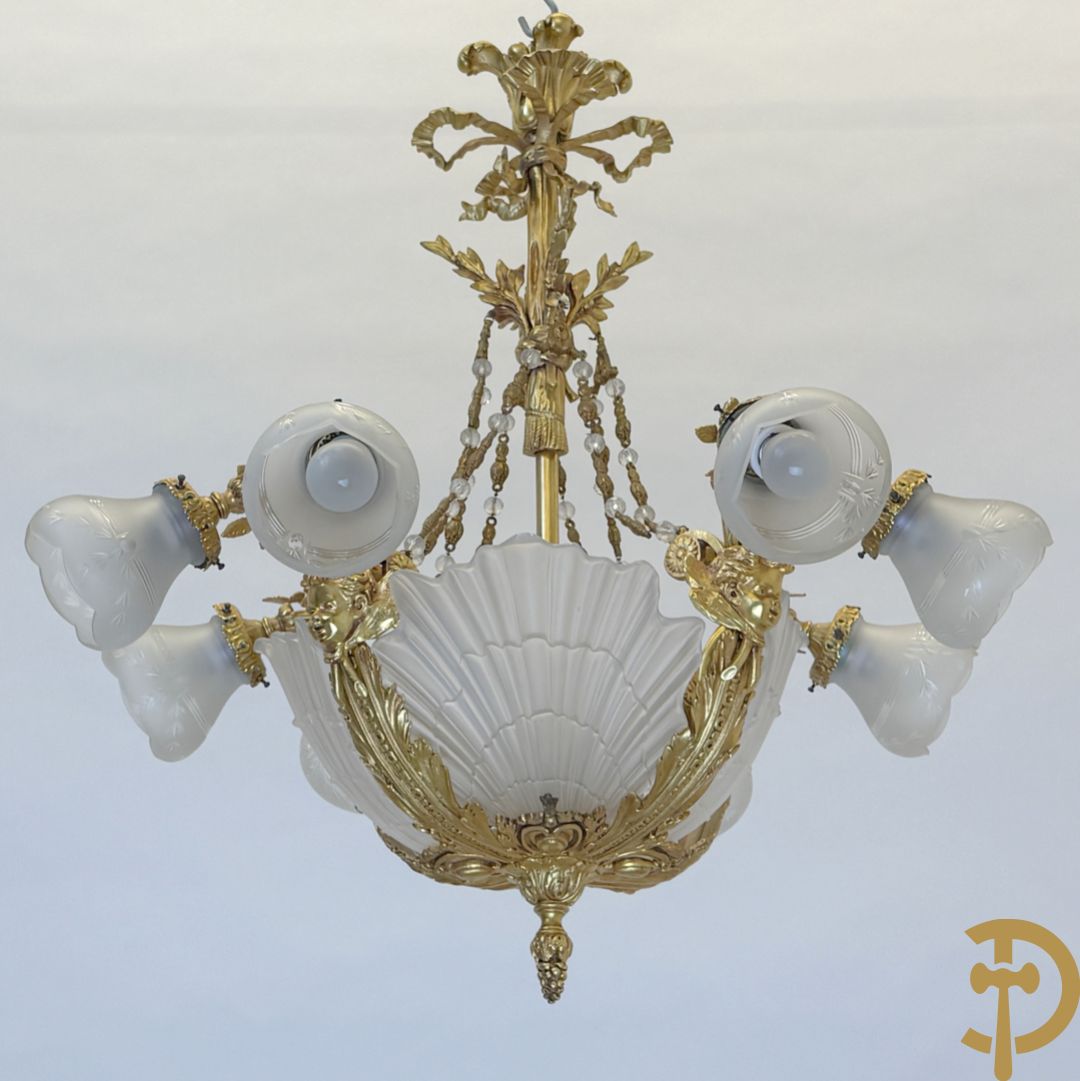 Bronzen vuurvergulde luchter met 4 paar lichtpunten bezet met bladranken, onderaan met glazen schelpen en armen bezet met cupidohoofden