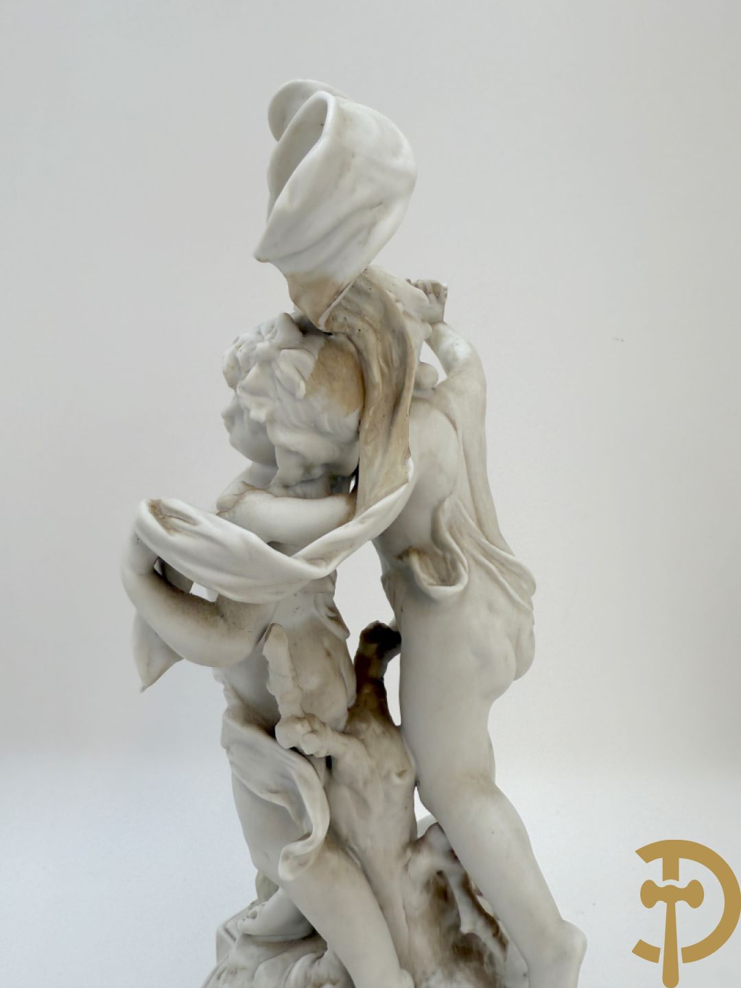 Driedelige porseleinen garnituur bestaande uit pendule bezet met lieftallig koppel, geflankeerd door paar kandelaars met cupido