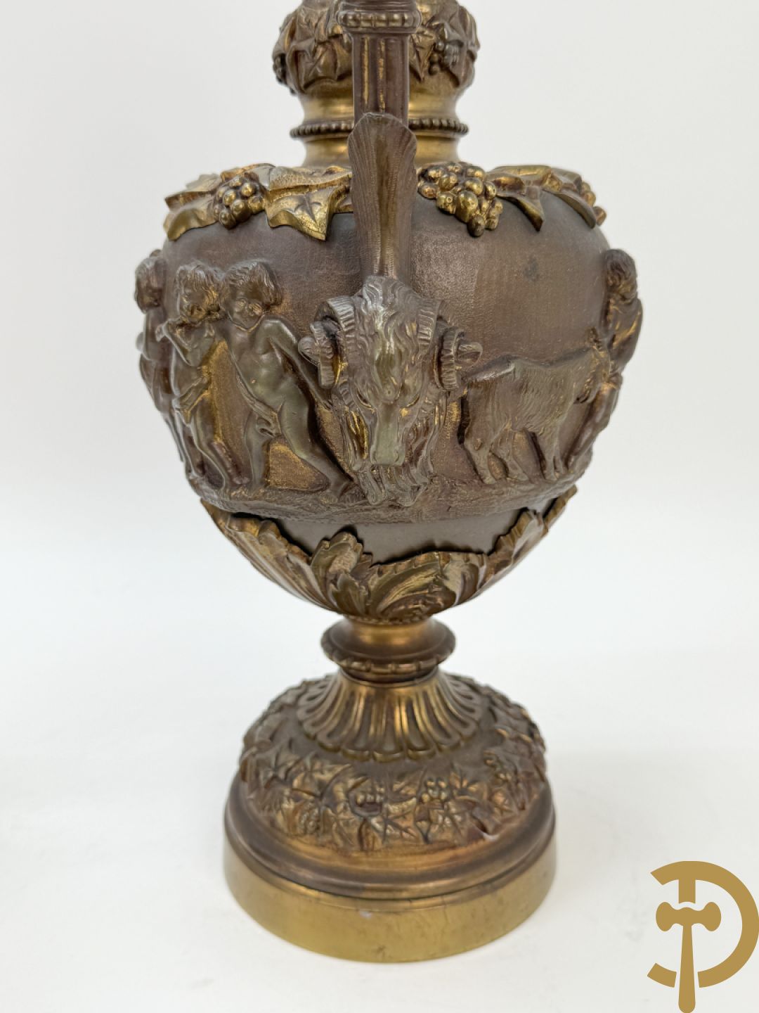 Paar bronzen schenkkannen met basrelief van putti en accanthusranken