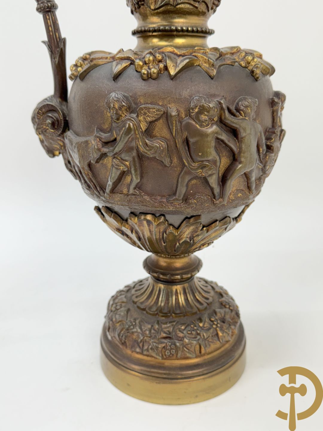 Paar bronzen schenkkannen met basrelief van putti en accanthusranken
